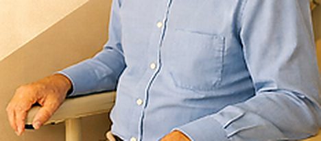 Smiling older adult safe and comfortable at home near a stairway